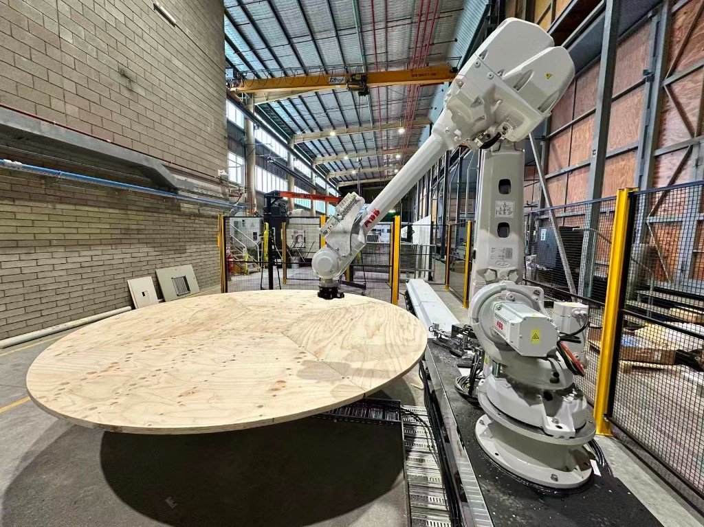 ABB industrial robot on a linear rail beside a 3-metre-radius turntable for structural assembly research