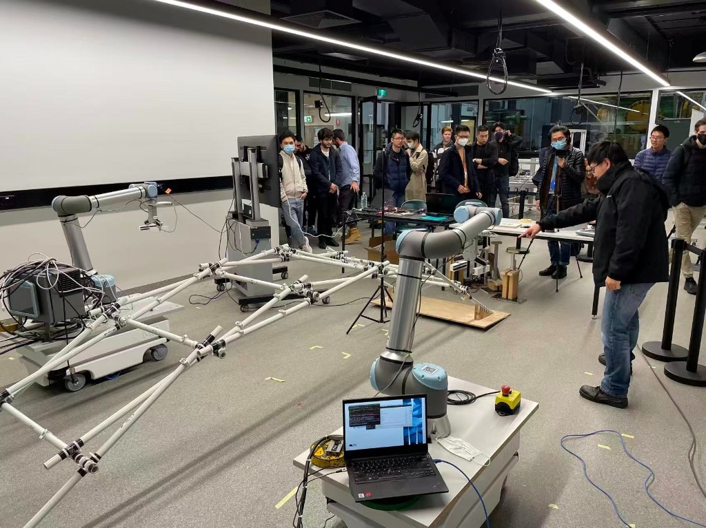 Two UR10e collaborative robots assembling a scaffold structure during a lab demonstration